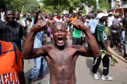 A man gestures as he celebrates in Bujumbura, Burundi May 13, 2015. Crowds poured onto the streets of Burundi's capital on Wednesday to celebrate after a general said he was dismissing President Pierre Nkurunziza for violating the constitution by seeking a third term in office, a Reuters witness said. REUTERS/Goran Tomasevic