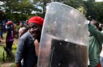 A man holds a riot police shield as he celebrates in Bujumbura, Burundi, May 13, 2015. REUTERS/Goran Tomasevic
